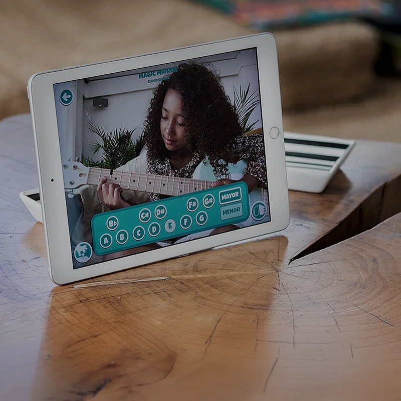 A tablet on a table showing the Loog app teaching a guitar chord